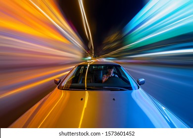 夜の街を走る車の前方からの眺め。高速で走る車とライトでぼやけた道路。