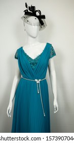 Turquoise Teal Gown Evening Dress on a white mannequin with white opaque pleated curtain background