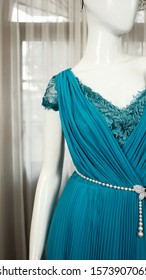 Turquoise Teal Gown Evening Dress on a white mannequin with white opaque pleated curtain background