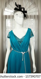 Turquoise Teal Gown Evening Dress on a white mannequin with white opaque pleated curtain background