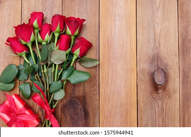 Rode rozen en geschenkdoos met lint, over houten achtergrond plat gelegd. Valentijnsdag, verjaardag abstracte achtergrond met kopie ruimte.