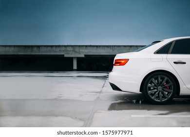 Modern car silhouette at the parking lot. The rear part of the modern sedan in the empty parking lot