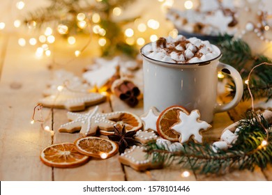 Winterheißgetränk: weißer Becher mit heißer Schokolade mit Marshmallow und Zimt. Gemütliche Wohnatmosphäre, festliche Urlaubsstimmung. Rustikaler Stil, hölzerner Hintergrund. Hausgemachte Lebkuchenplätzchen. Nahansicht