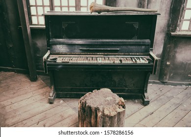 Piano rosak di bangunan lama yang kotor. Bilik kayu berdebu dengan alat muzik yang terlupa