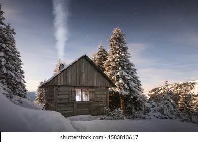 Fantástico paisaje invernal con casa de madera en montañas nevadas. El humo sale de la chimenea de la cabaña cubierta de nieve. concepto de vacaciones de navidad