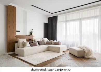 大きなコーナーソファ、木製の床、大きな窓のあるエレガントで快適なデザインのリビングルーム