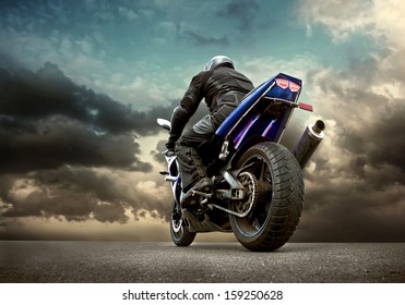 Man seat on the motorcycle under sky with clouds