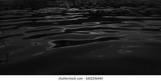 水のテクスチャー。水の反射テクスチャ背景。暗い背景、暗い水または油面の高解像度背景。海面の暗い自然の背景。川の湖の波打つ水。