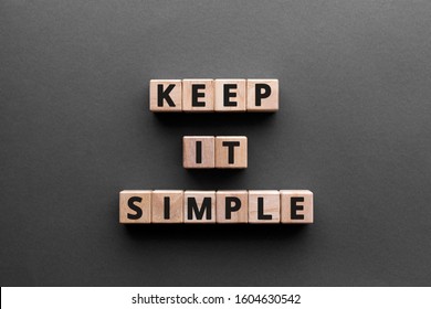 Keep it simple - word from wooden blocks with letters, to make something easy, keep it simple concept, gray background