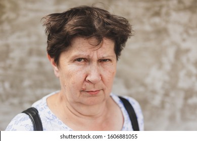 Retrato de mujer mayor audaz mirando con confianza al aire libre - Linda y carismática anciana con cabello castaño sintiéndose positiva y sin miedo mientras está de pie en la ciudad