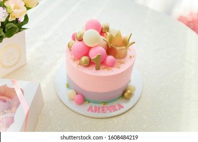 Djevojačka ružičasta torta sa kuglicama, zlatnom krunom i brojem 1. Proslava prvog rođendana stara godinu dana. Candy bar sa cvijećem i poklon kutijama. Natpis - Anny.
