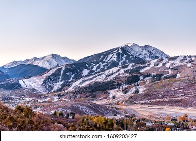 Vista en ángulo alto de las montañas rocosas de Aspen, Colorado, de tierras altas cubiertas de nieve y una pequeña pista de aeropuerto en el valle de Roaring Fork en otoño