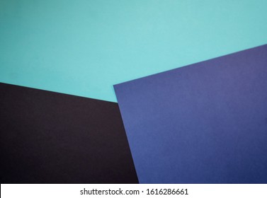 Abstract colored paper geometry background minimalist concept, flat lay top view, multicolored empty image with copy space for any design purposes, dark blue, light blue, simple black
