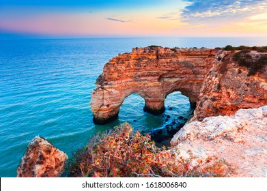 Heart-shaped cliffs on the shore of Atlantic ocean in Algarve, Portugal. Selective focus. Beautiful summer landscape.