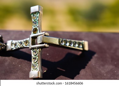Kreuzanhänger mit Edelsteinen isoliert mit schönem Hintergrund