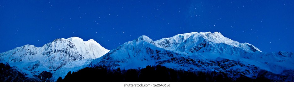 Montañas Gangapurna y Annapurna en el cielo azul con estrellas, Himalaya, Nepal