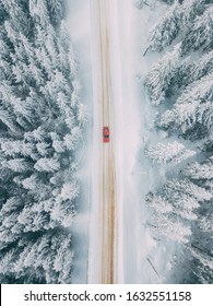 冬の山道を走る車。雪に覆われた木々の美しい空撮。場所: ララウ山脈、ルーマニア