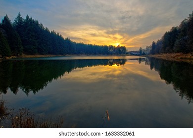 Der Meugliano-See ist ein eiszeitlicher Moränensee in Meugliano in Valchiusella, Piemont, Italien. Gesehen bei Sonnenuntergang an einem sonnigen Wintertag.