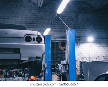 Sports drift car at night in a car service center