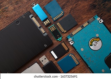 Gadgets de almacenamiento de memoria. SSD, disco duro, tarjetas SD, Compact Flash y Flashdrive sobre mesa rústica. Unidades de datos.