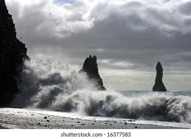 The waves of the Atlantic Ocean hitting the basalt and volcanic beaches of Iceland's south coast at Reynir, famous for it's troll-like landmasses, erecting out from the ocean