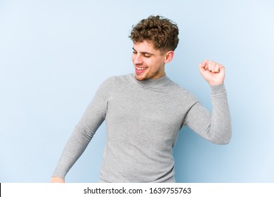 Young blond curly hair caucasian man isolated dancing and having fun.