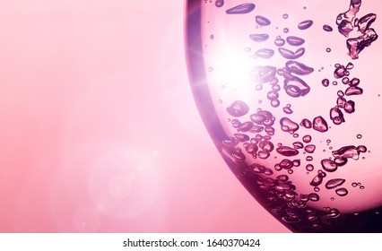 Ein Blasenspritzer aus transparenter, klarer Wasserflüssigkeit im Glas bei Sonnenlicht. urlaub heller hintergrund. Urlaub Postkarte Hintergrund. Weinglas mit Blasen