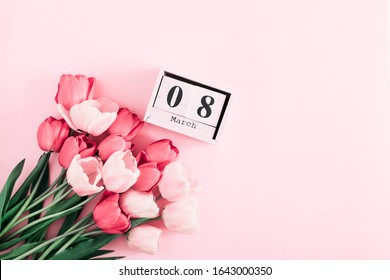 Schöne rosa Tulpen und Kalender auf pastellrosa Hintergrund. Konzept Frauentag, 8. März. 8. März. Flache Lage, Draufsicht, Kopierbereich