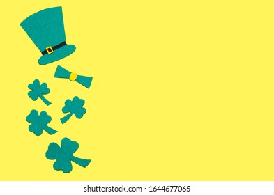 hari santo patrick di irlandia. semanggi hijau atau shamrock dan topi sebagai simbol pada latar belakang kuning dengan ruang fotokopi