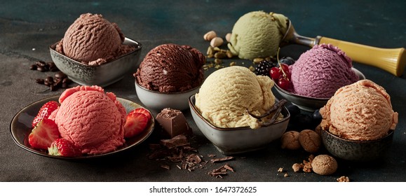 Postre de verano gourmet de helado artesanal o artesanal elaborado con bayas frescas, macarrones, granos de café, pistachos y chocolate servido en cuencos en un banner de gran angular