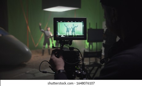 Medium shot of a cameraman watching the preparations and shooting a scene for a sci-fi movie