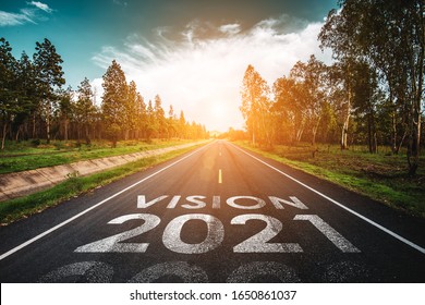 Visie 2021 geschreven op snelwegweg in het midden van lege asfaltweg bij gouden zonsondergang en mooie blauwe lucht. Concept voor het nieuwe jaar 2021.