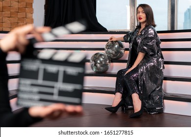 Blurred Clapper Board And Woman Actor On Stage. Producing TV Series Or Movie. Movie Or Clip Production Backstage. Singer Super Star Near Discoballs. Stay Home In Isolation And Watch Online Movie.