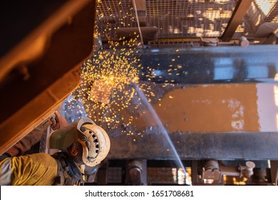 Work safety practise spotter, firewatch personal holding firehose spraying water where spark frames dropping onto the conveyor belt during welder wearing PPE conducting oxy cutting metal repairing