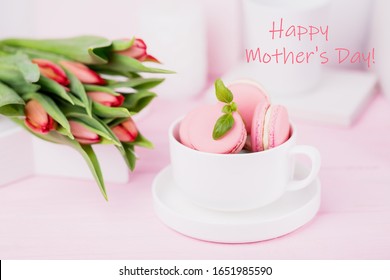 Chúc mừng ngày của mẹ khái niệm. Dòng chữ, văn bản, từ ngữ. Bánh macaron màu hồng và hoa tulip mùa xuân trên nền màu hồng