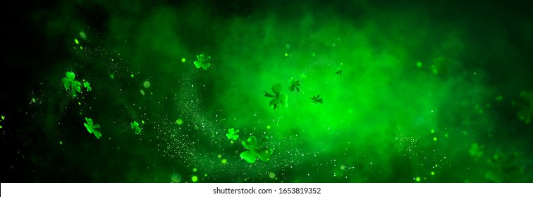 Abstrakter grüner Hintergrund des St. Patrick's Day, verziert mit Kleeblattblättern. Patrick Day Pub Party feiert. Abstrakter Grenzkunstdesignzauberhintergrund. Breitbildklee auf Schwarz mit Kopierraum.