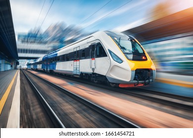 Tàu cao tốc chuyển động trên nhà ga lúc hoàng hôn. Tàu khách liên tỉnh hiện đại với hiệu ứng mờ chuyển động trên nền đường sắt. Công nghiệp. Đường sắt ở Châu Âu. Vận tải thương mại