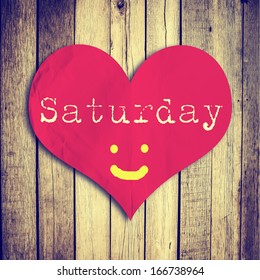 Love Saturday on red heart shape with wooden wall
