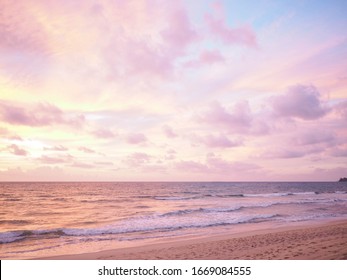 Farbiger Sonnenuntergang am tropischen Strand mit schönem Himmel, Wolken, sanften Wellen
