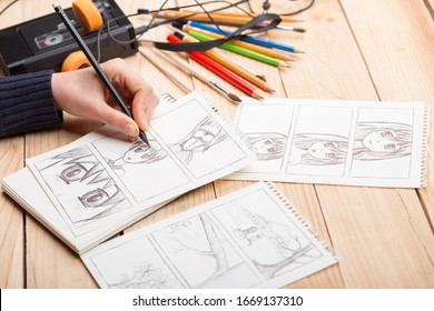 Artista dibujando un cómic de anime en un estudio. Escritorio de madera, luz natural. Concepto de creatividad e inspiración.