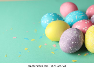Huevos de Pascua multicolores sobre fondo menta, espacio para texto.