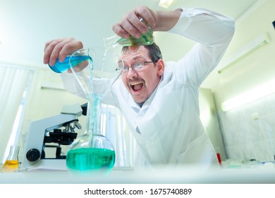 Chemist crazy. A mad scientist conducts experiments in a scientific laboratory. With a mad expression on his face, he mixes two liquids in a flask. COVID-19. COVID Coronavirus