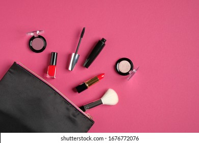 Makeup bag organizer with cosmetic products and professional make-up artist tools on pink background. Flat lay, top view. Beauty and fashion concept.