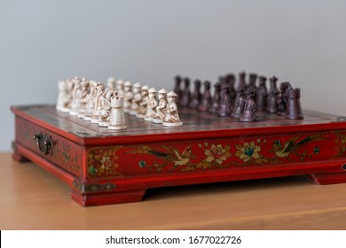 Wunderschönes chinesisches rotes Schach-Miniatur-Brettspiel der Armee aus kleinen Holzschnitzereien ist ein Strategie-Brettspiel für Spieler auf beiden Seiten. Sport, der das Gehirn nutzt und Meditation gut übt