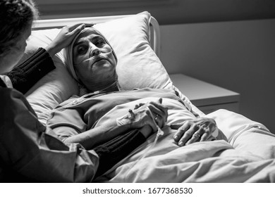 Hija apoyando a una mujer triste y moribunda con un tumor en un hospital, foto en blanco y negro