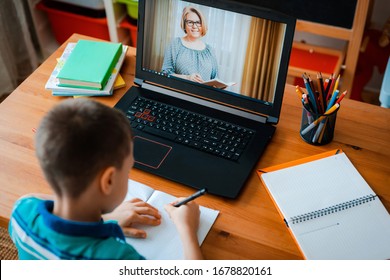Educación a distancia en línea. Un niño estudia en casa y hace los deberes escolares. Un aprendizaje a distancia desde casa.