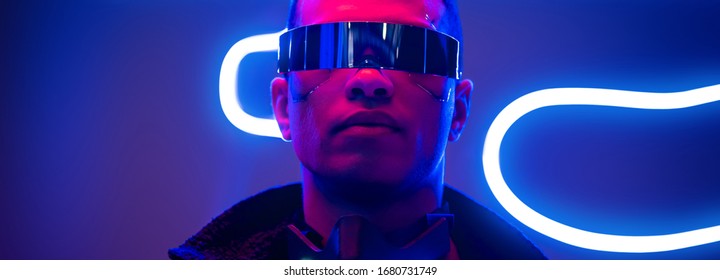panoramic shot of mixed race cyberpunk player in futuristic glasses near blue neon lighting