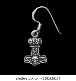 Silver earring. Jewelry. Thor's hammer.