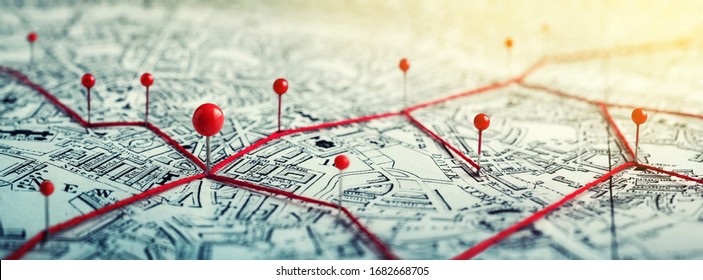 Các tuyến đường có ghim màu đỏ trên bản đồ thành phố. Khái niệm về các chủ đề phiêu lưu, khám phá, điều hướng, giao tiếp, hậu cần, địa lý, vận tải và du lịch.