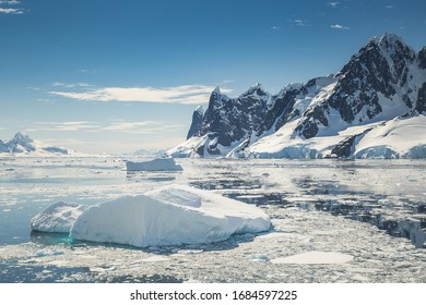 Paisaje de la península de la Antártida con gente, barcos, botes tiernos, pingüinos, icebergs y montañas